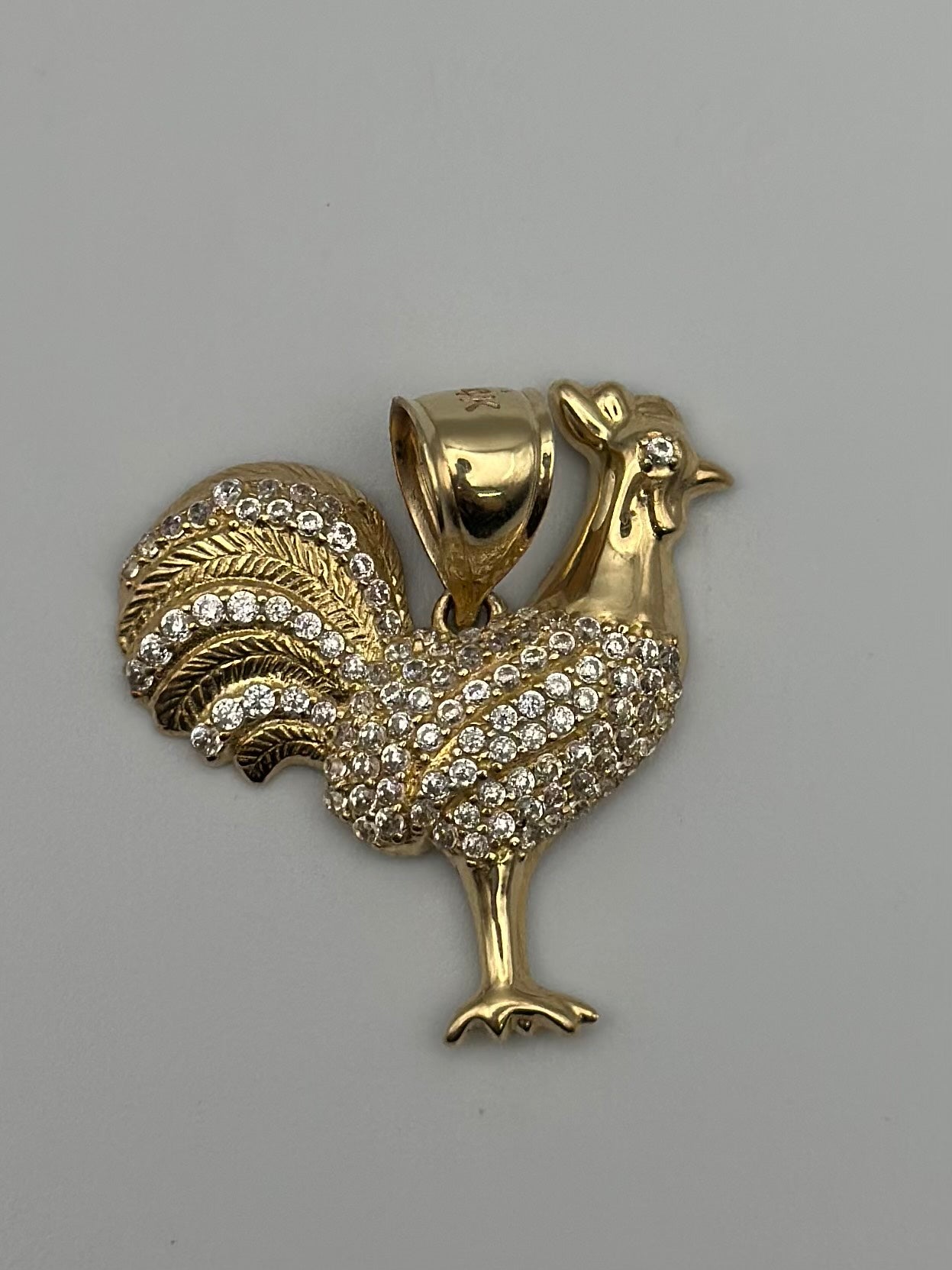 Medalla de gallo con zirconia blanca.